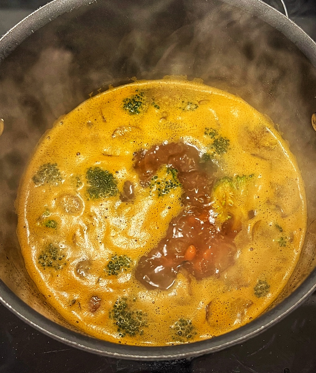 Vegan ramen broth with vegetables cooking in pot
 